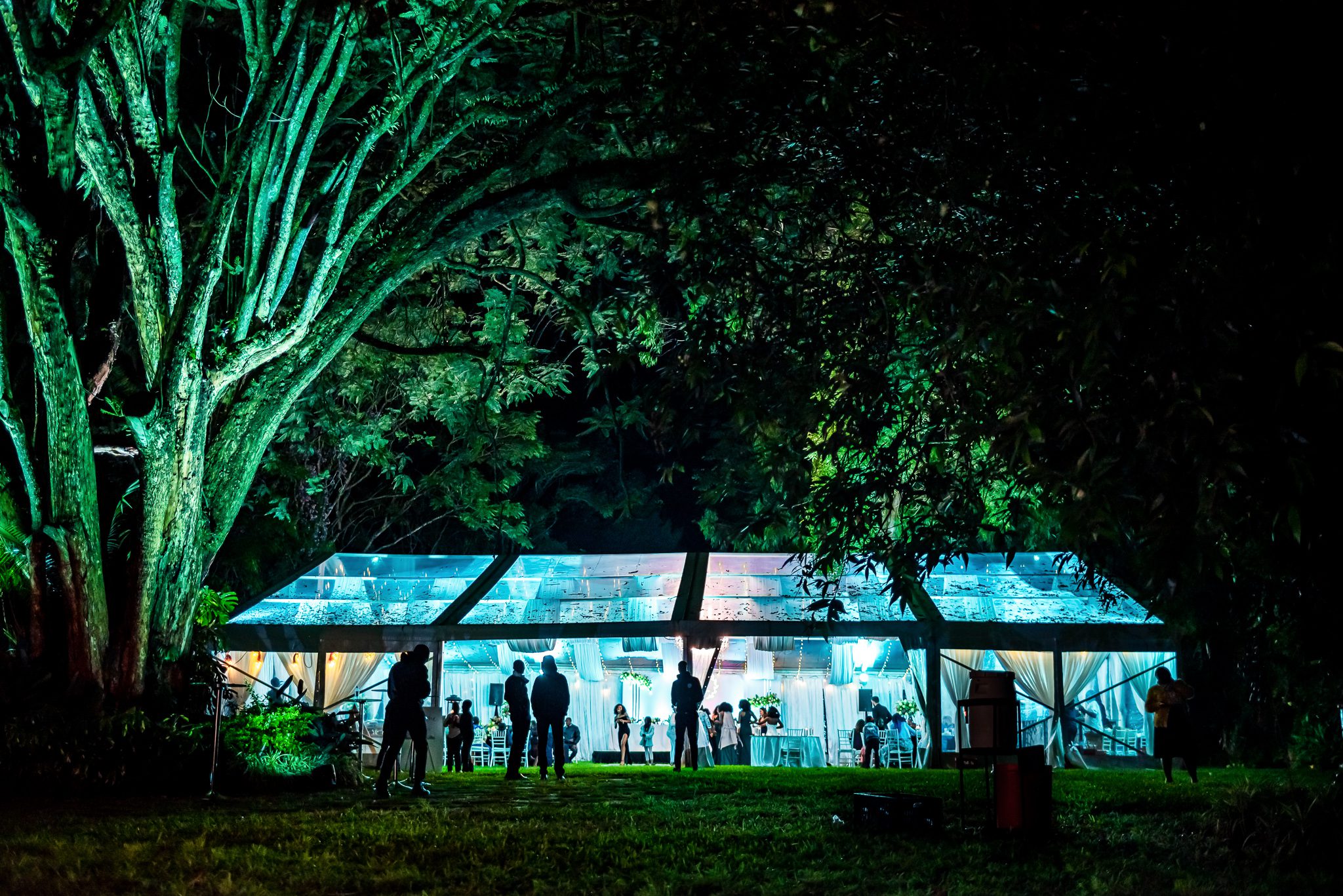 an event tent that is lit from the inside in a forest at nighttime in Nairobi Kenya for the wedding of James and Lorna