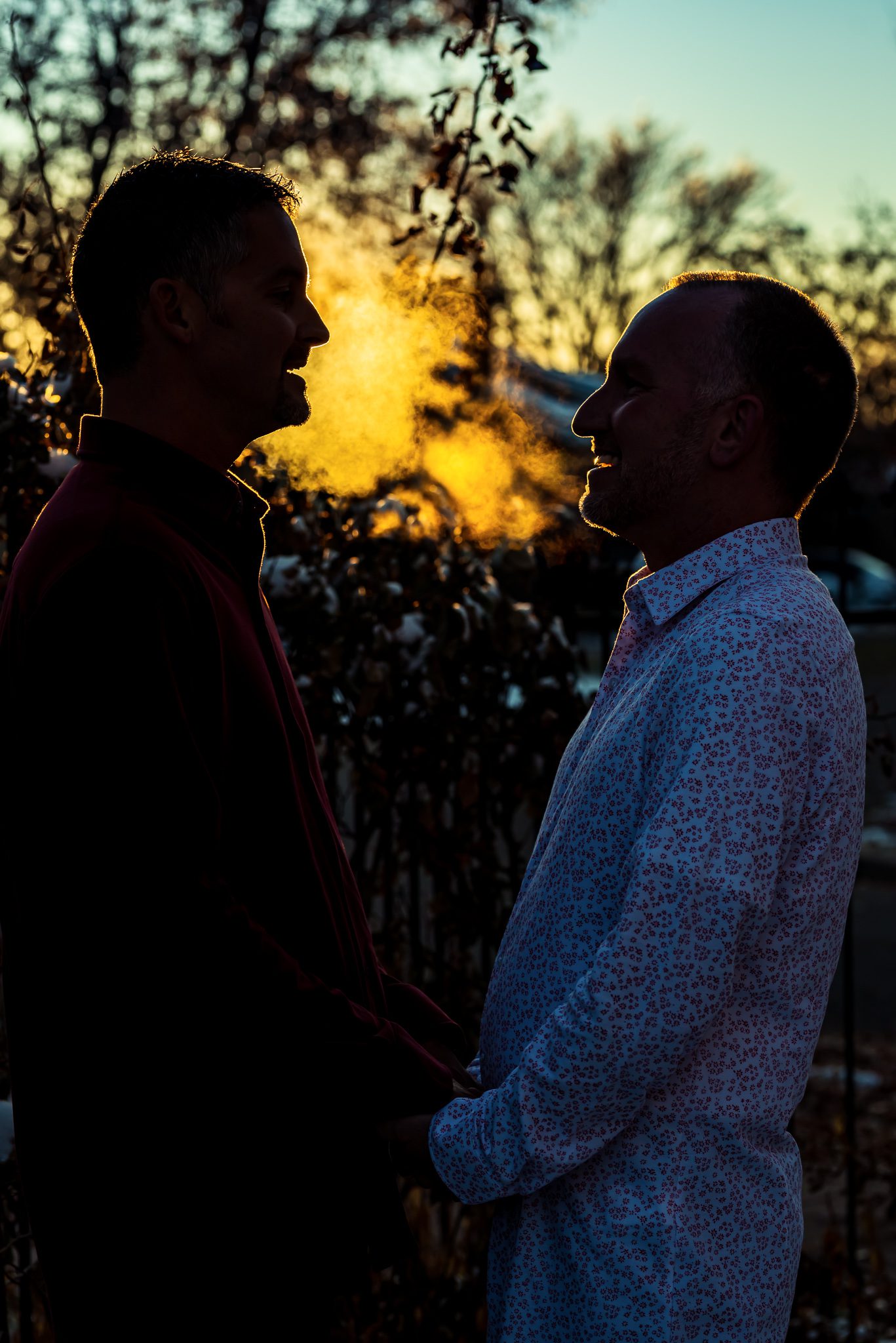 two men stare into each others eyes during dusk on their wedding day in Denver, CO
