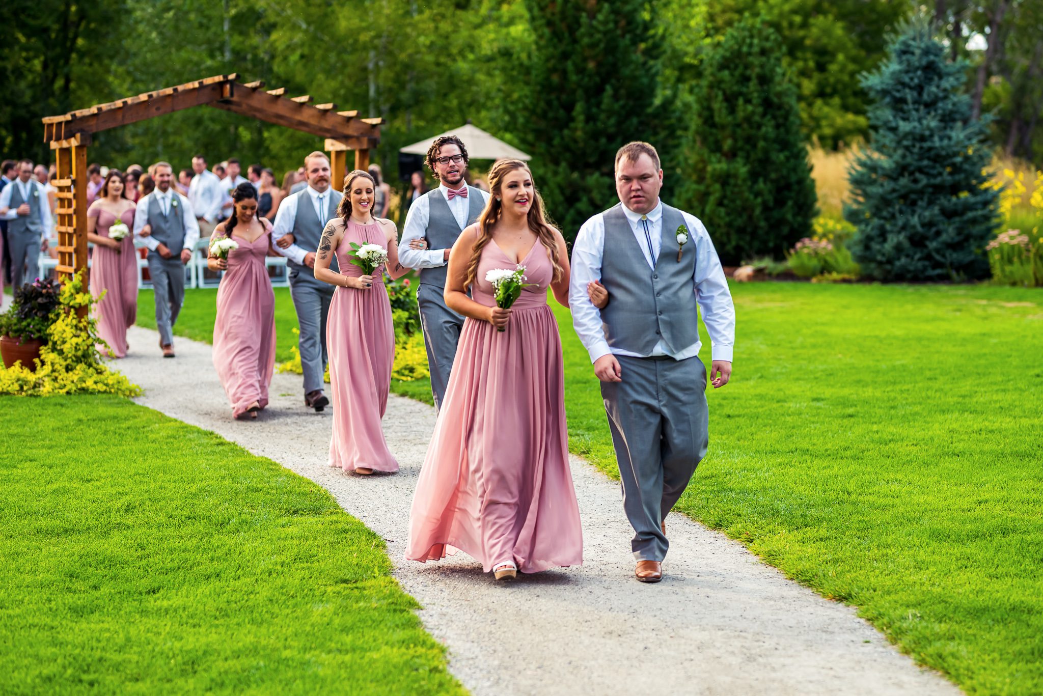 Bridesmaids and groomsmen walk down the isle at Chatfield Farms