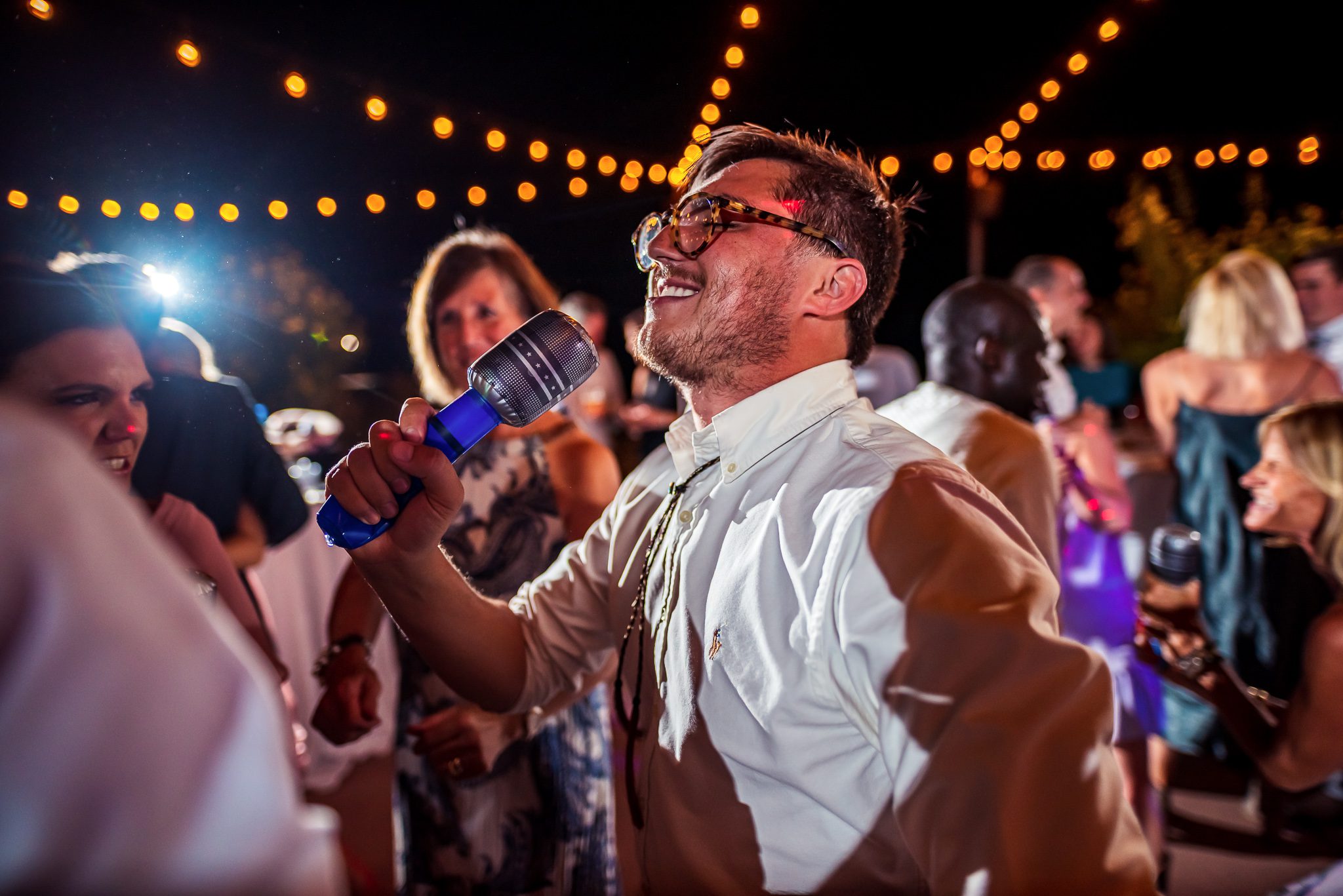 Guest sings into microphone at wedding reception party