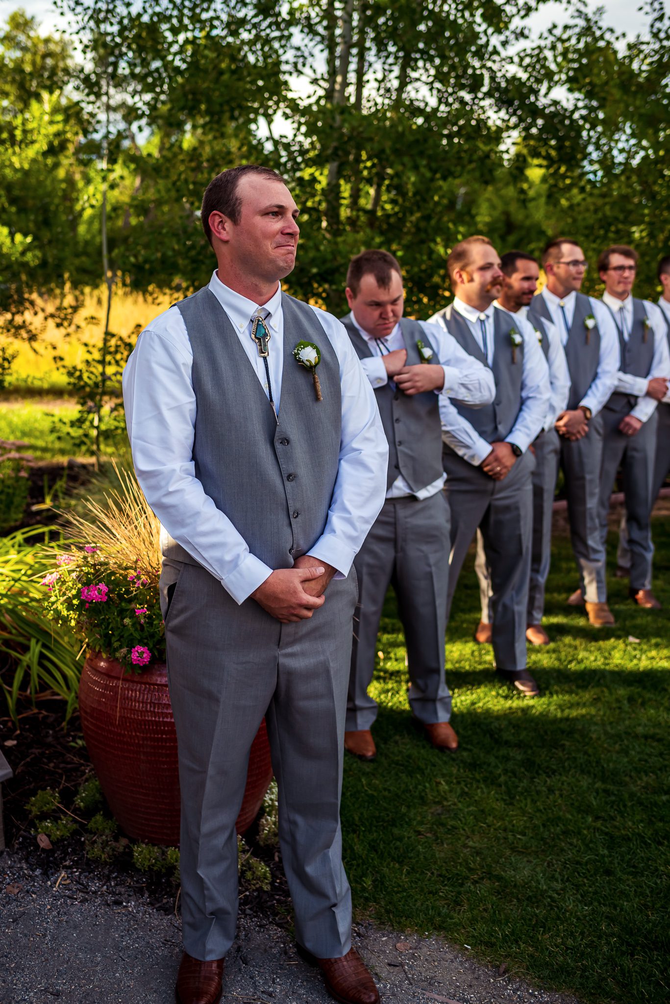 A groom stands waiting for his bride to walk down the isle during their wedding at Denver Botanic Gardens Chatfield Farms